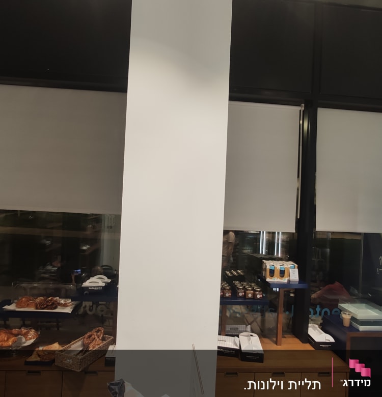 חנות עם מדפים, מאפים ומקרר תצוגה מואר